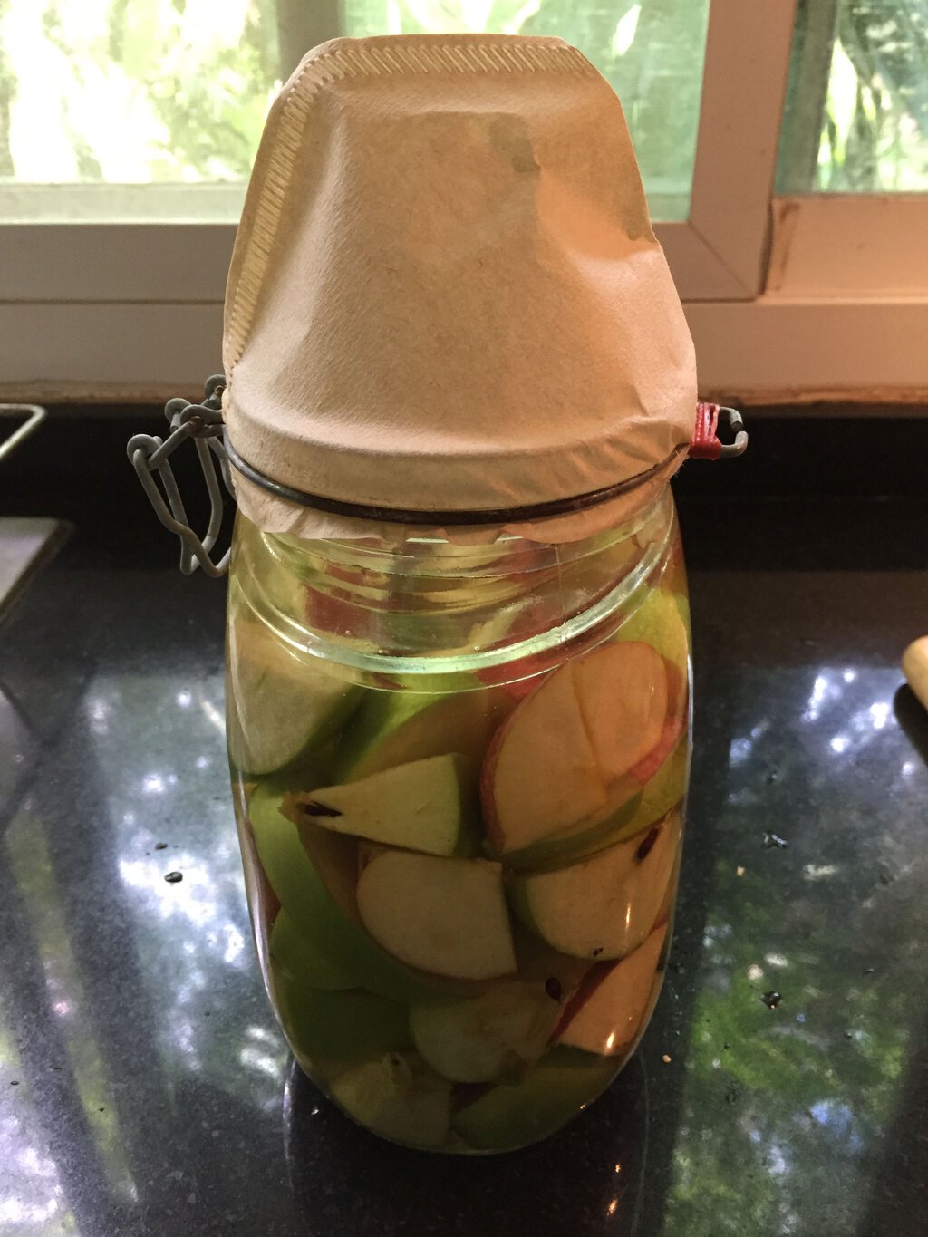 Chopped apples in fermentation jar with sugar solution